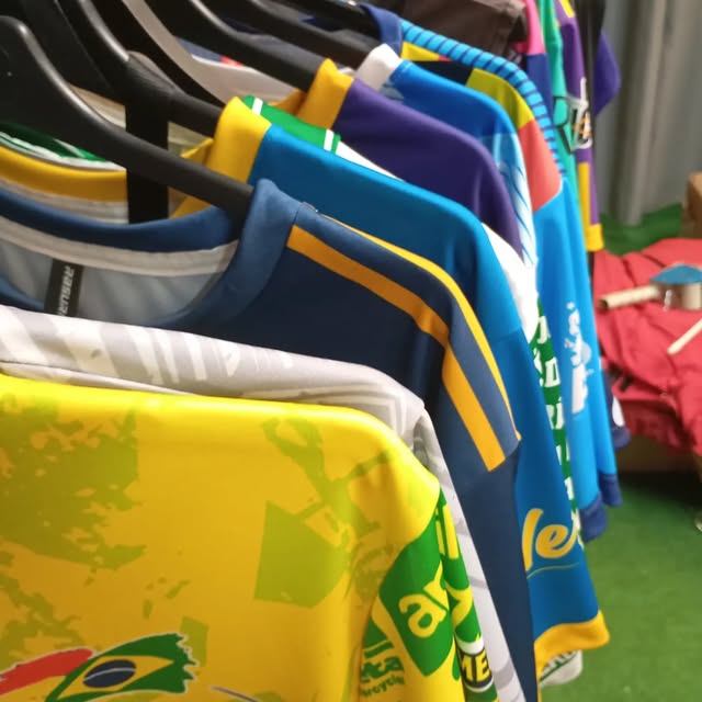 Varias camisetas deportivas Rasuri colgadas para mostrar sus diseños y colores